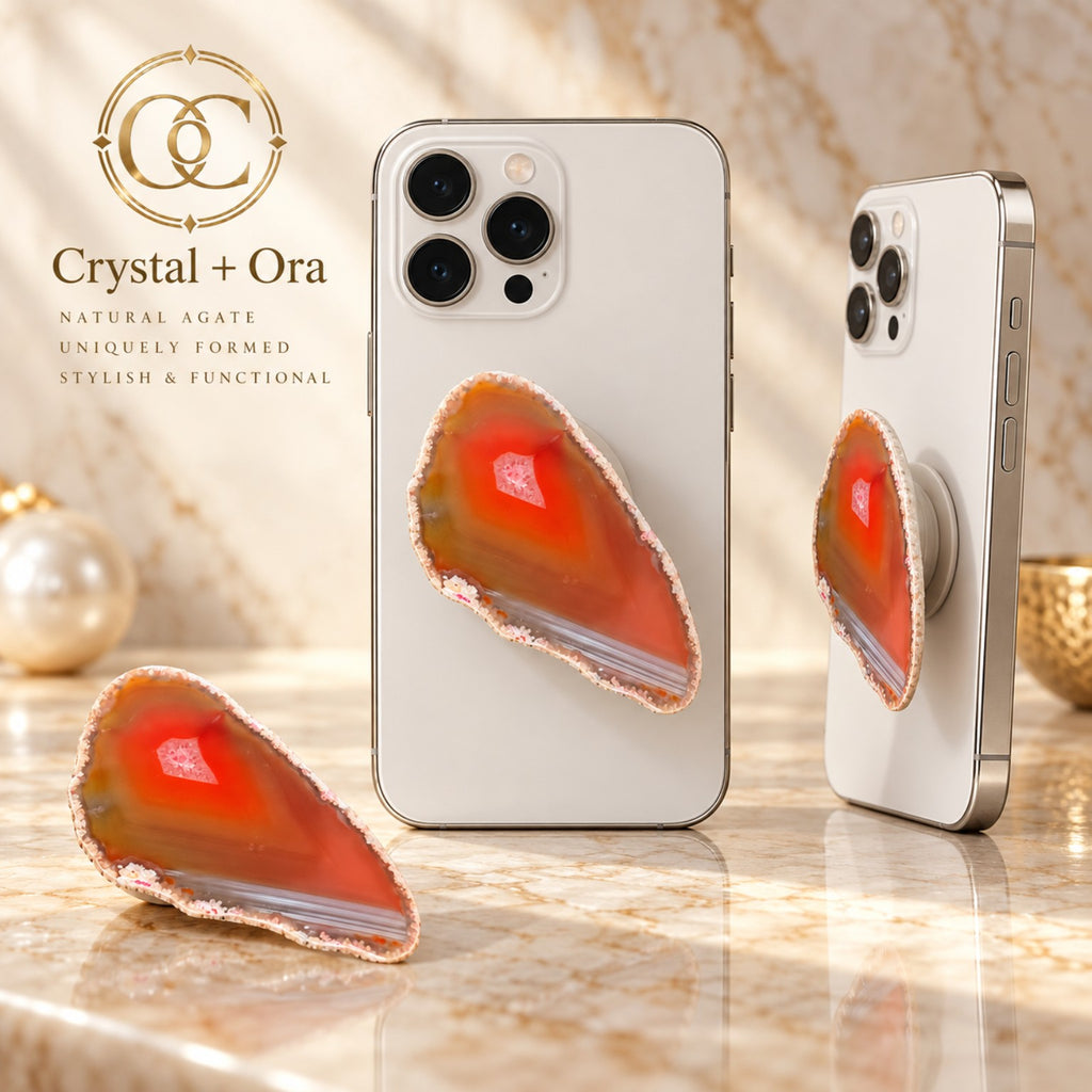 Amber-orange agate adhesive phone grip with a pale pink center detail and fine gray-white bands along the lower portion